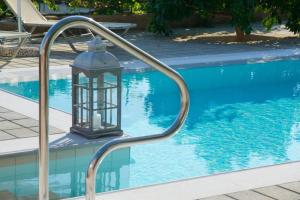 a lantern sitting next to a swimming pool at Liogerma Art Deco Villa - 5 min drive to Lassi in Sarláta