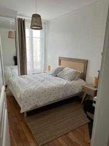 a white bedroom with a bed and a window at Appartement refait à neuf au pied de paris Paris in Saint-Ouen