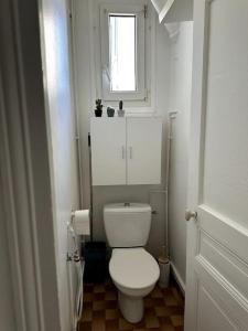 a bathroom with a white toilet and a window at Appartement refait à neuf au pied de paris Paris in Saint-Ouen
