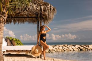 a woman in a black bikini standing on the beach at Hyatt Ziva Rose Hall - All Inclusive in Montego Bay