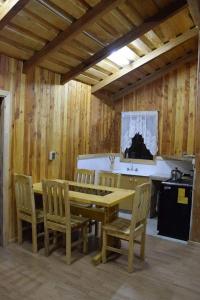 comedor de madera con mesa y sillas en Magma Conguillio, en Melipeuco