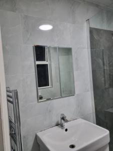 a white bathroom with a sink and a mirror at Home away from home in Leicester