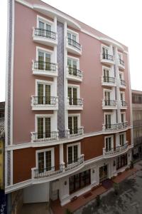 a pink building with balconies on a street at Maywood Hotel in Istanbul