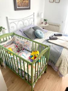 a green crib with toys in it in a bedroom at SANTA LUCÍA Garaje privado in Zamora