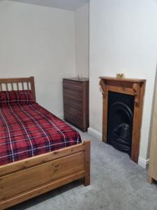 a bedroom with a bed with a fireplace and a dresser at Home away from home in Leicester