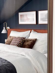 een slaapkamer met blauwe muren en een bed met kussens bij 3 min walk-MEIR Cozy 3-4BR house in Antwerpen
