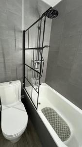 a bathroom with a white toilet and a bath tub at Studio la Mongie Tourmalet 2 étoiles in Bagnères-de-Bigorre