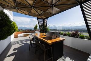 an outdoor kitchen with a table and chairs on a balcony at Amazing Volcano Views in front of airport in Guatemala
