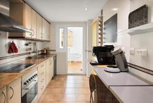 a kitchen with white cabinets and a counter top at Estepona Puerto Blanco Appartement - Casa Valk in Estepona