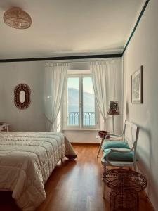 1 dormitorio con 1 cama, 1 silla y 1 ventana en Miralago Casa Vacanze, en Riva di Solto