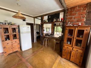cocina con nevera blanca y armarios de madera en Casa da Reserva en Santana do Riacho