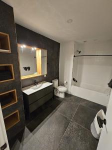 a bathroom with a sink and a tub and a toilet at Dream Living in Syracuse