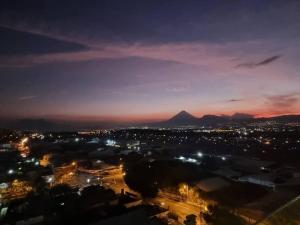 Amazing Volcano Views in front of airport في غواتيمالا: مدينة في الليل مع جبل في الخلفية