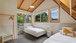 梅顿Lakeview Treehouse的一间卧室设有两张床、一把椅子和窗户。