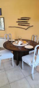 drewniany stół z białymi krzesłami i jadalnia w obiekcie La casa de Su w mieście Neuquén