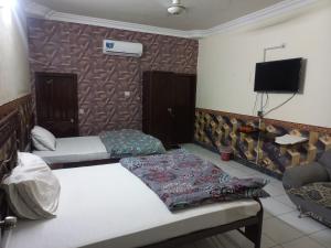 Habitación con 2 camas y TV de pantalla plana. en New Al Rehman Guest House, en Hyderabad
