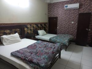 Habitación con 2 camas y pared en New Al Rehman Guest House, en Hyderabad