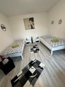 two beds sitting in a room with wooden floors at Ferienhaushälfte Knobloch in Oberhausen