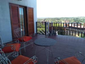een patio met een tafel en stoelen en een balkon bij Apartamentos Anahí in Villa Parque Siquiman