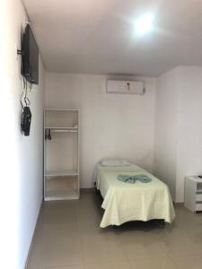 a small bedroom with a bed and a television at Carolina Palace Hotel in Carolina