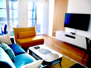salon z kanapą i telewizorem w obiekcie Horizon w mieście Le Plessis-Robinson
