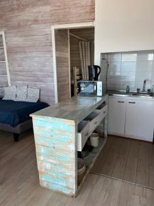 a kitchen with a counter with a microwave and a sink at Muelle Apart Hotel in Tongoy