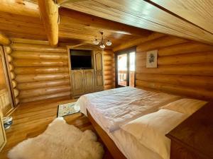 una camera con un letto in una baita di tronchi di DADA Chalet - Vatra Dornei, Bucovina a Vatra Dornei