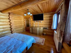 una camera con un letto in una baita di tronchi di DADA Chalet - Vatra Dornei, Bucovina a Vatra Dornei