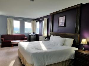 una habitación de hotel con una cama grande y una silla en Florenceville Inn, Restaurant & Pool, en Florenceville