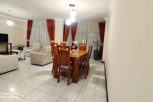 a living room with a table and chairs and a couch at Departamento frente a Plaza Sucre, vista panorámica, 6 personas, 2 habitaciones, ascensor, garaje extra in Tarija