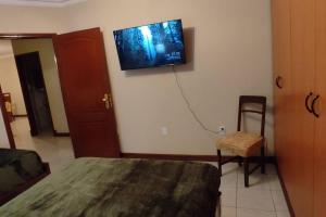 a bedroom with a bed and a tv on the wall at Departamento frente a Plaza Sucre, vista panorámica, 6 personas, 2 habitaciones, ascensor, garaje extra in Tarija