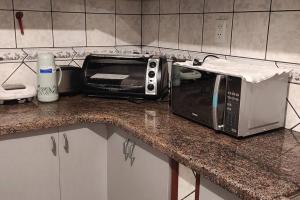 a microwave sitting on a counter in a kitchen at Departamento frente a Plaza Sucre, vista panorámica, 6 personas, 2 habitaciones, ascensor, garaje extra in Tarija