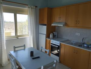 uma cozinha com uma mesa, um lavatório e um fogão em Argilos Apartments em Frangocastelo