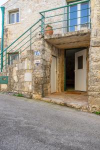 una entrada a un edificio de piedra con una escalera en O Refúgio das Buracas, en Condeixa a Nova