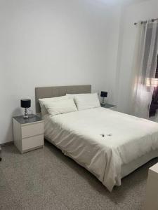 1 dormitorio con 1 cama blanca grande y 2 mesitas de noche en Casa Pérez, en Aguilar de la Frontera