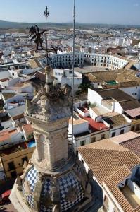 a building with a statue on top of a city at Casa Pérez in Aguilar de la Frontera +6 photos