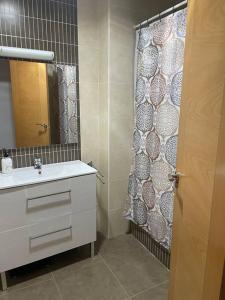 baño con lavabo y cortina de ducha en Casa Pérez, en Aguilar de la Frontera