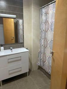 a bathroom with a sink and a shower curtain at Casa Pérez in Aguilar de la Frontera
