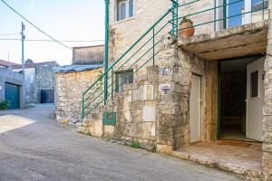 un edificio de piedra con una puerta y escaleras. en O Refúgio das Buracas, en Condeixa a Nova