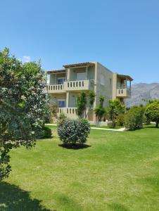 uma casa grande com um quintal com relva verde em Argilos Apartments em Frangocastelo