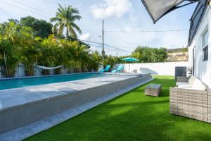 una imagen de un patio trasero con piscina y césped en Miami 4Bedroom Retreat heated Pool near to beach, en North Miami Beach