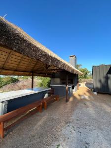 een paviljoen met banken en een rieten dak bij Casa Conteiner en campo con playa privada. max 6 personas in Jaureguiberry