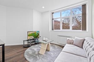 ein Wohnzimmer mit einer weißen Couch und einem Tisch in der Unterkunft Leicester Aparthotels - Churchgate in Leicester