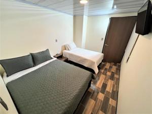 um quarto com duas camas e uma tv nele em HOTEL ANGELES J&A em Tunja