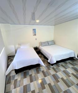 um quarto com duas camas num quarto em HOTEL ANGELES J&A em Tunja