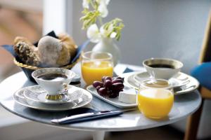 una mesa con platos de comida y tazas de zumo de naranja en Fritz im Pyjama, en Hamburgo