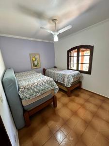 um quarto com duas camas e uma cadeira em Chácara Marretto, ambiente acolhedor e familiar dentro da cidade de Tatuí. em Tatuí