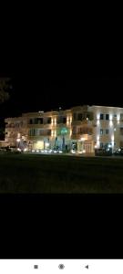 un gran edificio con luces delante de él por la noche en Grandino rooms&apart, en Ulcinj