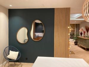 a room with two mirrors on a wall with a chair at Maison Paisible au coeur des Pyrénées in Igon