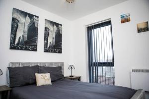 a bedroom with a bed with two pictures on the wall at Stylish two-bedroom Salford Quays apartment in Manchester